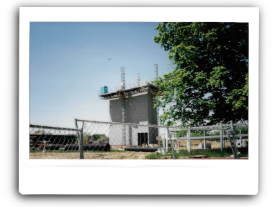 an instant picture of a porta potty high above the ground on a partially constructed building