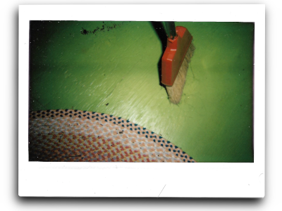 an instant picture of a red broom against a green floor