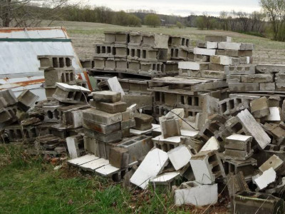 a big pile of cinder blocks in midwest field