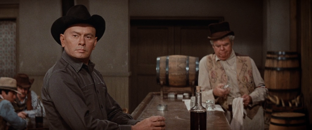 a screenshot from the film 'westworld' (1973) showing a gay cowboy robot looking down a bar at a character outside of the frame